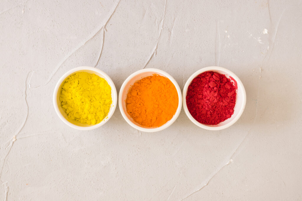 une-vue-elevee-de-bols-blancs-avec-de-la-poudre-de-couleur-holi-sur-fond-simple